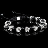 Lukze 925 sterling silver skull and black onyx macramé bracelet on a black reflective surface