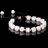 Lukze Mother of Pearl and rose gold macramé bracelet with white cubic beads on a black background