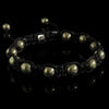 Lukze Golden Pyrite Shamballa Bracelet with black braided cord on a black background